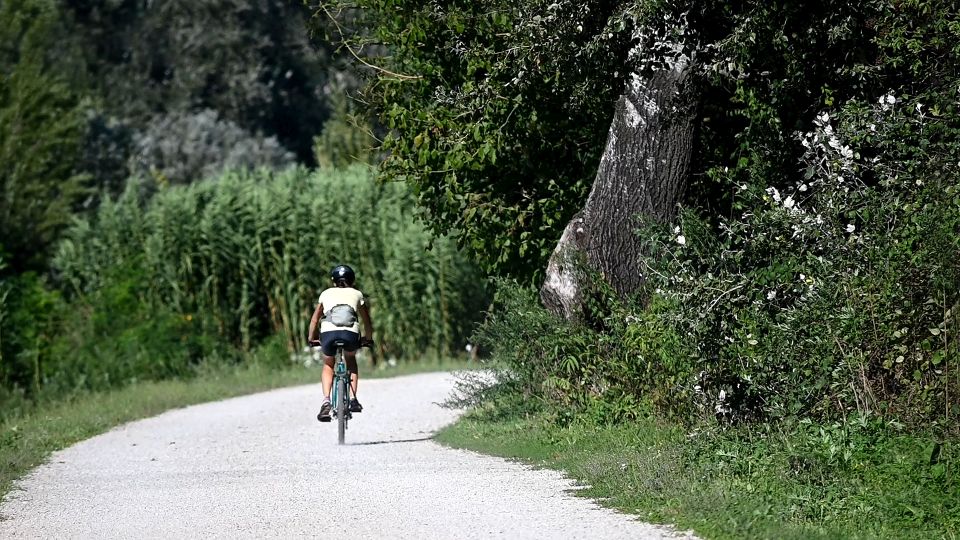 ciclista sulla Ciclabile Puccini sul fiume serchio nella Piana di Lucca
